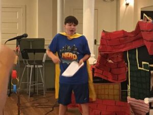 Evan Wells, 13, leads 2017 VBS with a “heroic” skit. Photo by Laura Wells.  